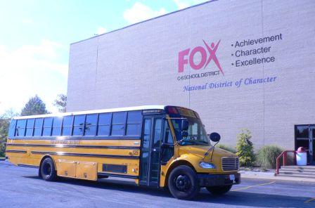 School Bus in front of logo